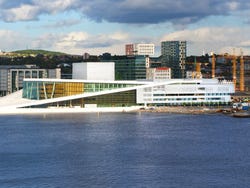 A large modern white building on an open waterfront